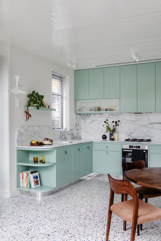 https://www.digsdigs.com/photos/2023/03/a-mint-blue-kitchen-with-flat-panel-cabinets-a-white-terrazzo-floor-and-a-white-marble-backsplash-a-stained-dining-set.jpg