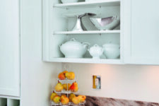 a mint blue kitchen with shaker cabinets, an open compartment in an upper cabinet, stone countertops is a chic idea