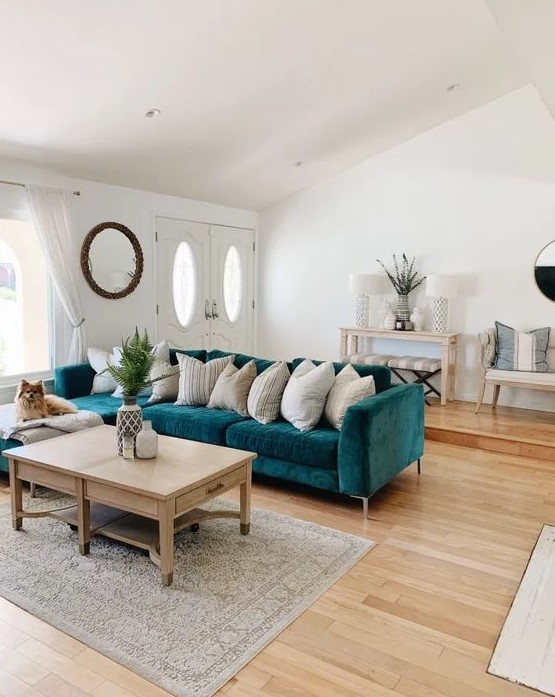a modern beachy living room with a turquoise sofa, neutral textiles, a wooden coffee table and lovely wooden furniture