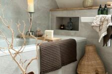 a modern earthy bathroom with grey stone-inspired tiles, a built-in tub, a floating sink, a woven rug and baskets