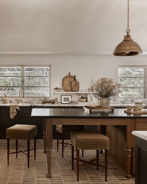 a modern earthy kitchen with dark lower cabinets, a stained kitchen island with an eating zone, a pendant lamp and open shelves