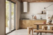 a modern earthy tone kitchen with stained wooden beams, plywood lower cabinets, a marble tile backsplash and a stone tile floor