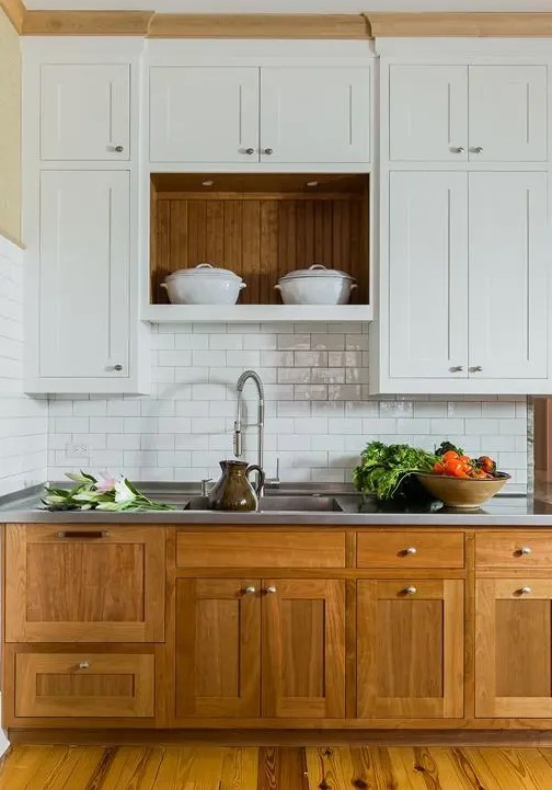 a modern farmouse kitchen with lower stained cabinets, upper white ones, a white subway tile backsplash, a metal countertop for a cozy look and maximal functionality