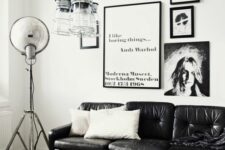 a monochromatic Scandi living room with a black leather couch, a gallery wlal, pendant jar lamps and a coffee table