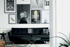 a monochromatic black and white living room with a catchy black sofa, a black and white gallery wall, a side and a coffee table and a brown leather pouf