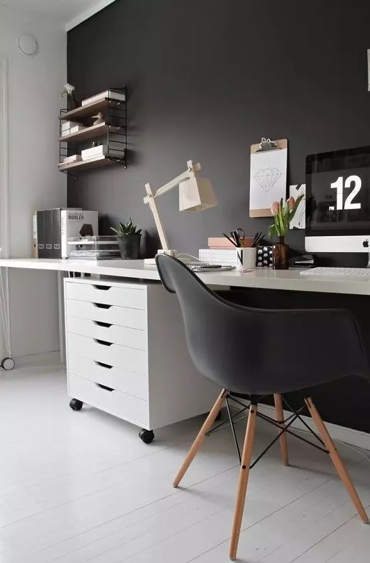 a moody Scandi home office with a black statement wall, Eames chair and some decor and white as the base