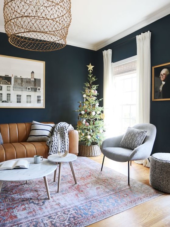 a moody living room with black walls and light and warm colored furniture, an amber leather striped sofa