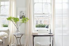 a refined light-filled space with white double-hugn windows with delicate framing, lightweight furniture and a crystal chandelier