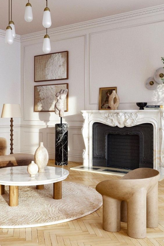 a refined neutral living room with a French fireplace, warm-colored seating furniture, a low coffee table and some art