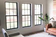a series of black frame double-hung windows gives a lot of light and contrasts the neutral space with its black framing
