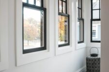 a series of black frame double-hung windows gives a lot of natural light to the space and adds interest with black framing