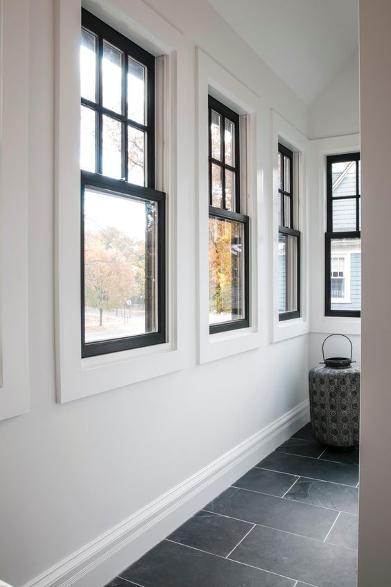 a series of black frame double-hung windows gives a lot of natural light to the space and adds interest with black framing