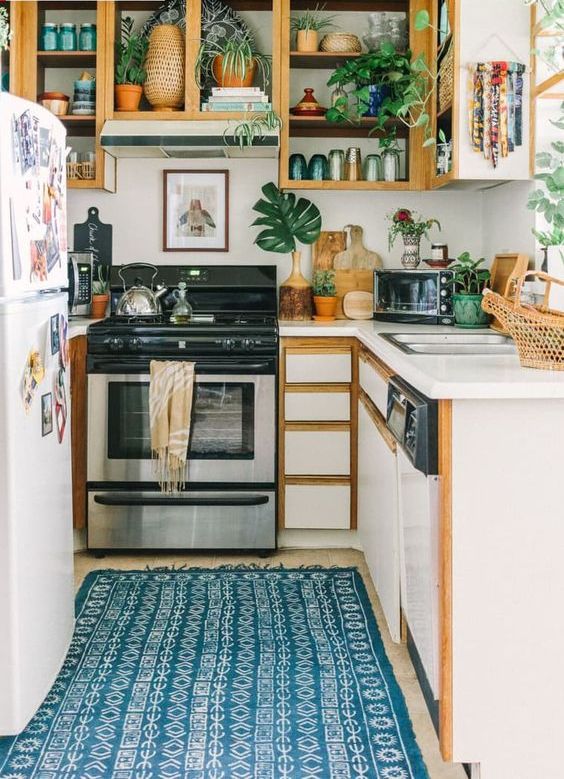 a small and lovely kitchen with white and stained opn cabinets that are used for displaying dishes, jars and potted plants