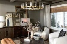 a sophisticated living room in earthy tones, with grey walls and a ceiling, a dark-stained credenza, white chairs, a round coffee table and a rust-colored upholstered bench