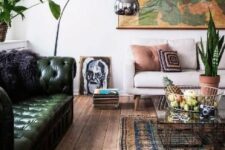 a stylish living room done with a green leather Chesterfield sofa, a vintage map, a bold boho rug, some plants and a floor lamp