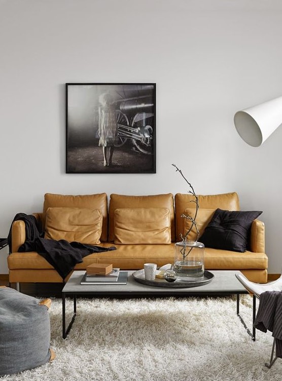 a stylish monochromatic living room in contemporary style, with a yellow leather sofa as a colorful statement