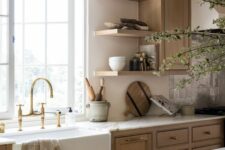 a welcoming earthy kitchen with stained cabinets and a kitchen island, rough stained wooden beams and open shelves