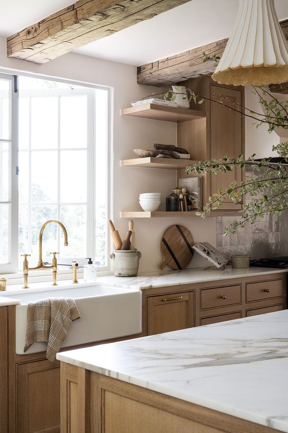 a welcoming earthy kitchen with stained cabinets and a kitchen island, rough stained wooden beams and open shelves