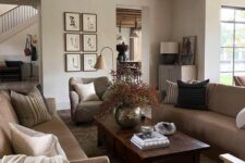 a welcoming modern earthy living room with greige seating furniture, a low dark-stained coffee table, a grid gallery wall and a potted plant