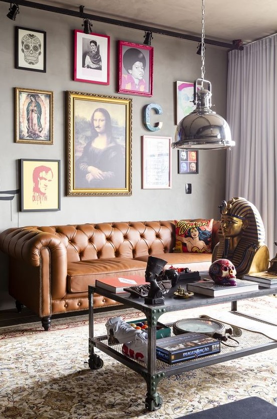 a whimsical industrial living room with a brown leather Chesterfield sofa, a bold and quirky gallery wall and a metal table