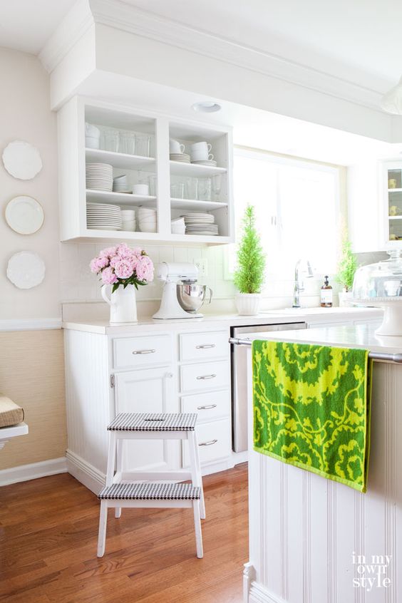 a bright kitchen with white cabients and an IKEA stool