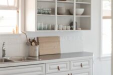 a white kitchen with open upper cabinets, a tile kitchen backsplash and leather pulls is a very cozy idea