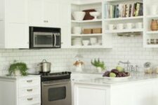 a white kitchen with shaker and open cabinets, a white subway tile backsplash, white countertops and potted greenery