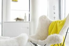 an airy nook with a white faux fur butterfly chair and a footrest, a bold yellow blanket and a yellow pendant lamp