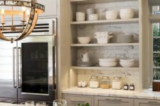 an elegant grey kitchen with shaker and open cabinets, white marble tiles and countertops and a cool sphere pendant lamp