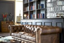 an elegant moody home office with a brown leather Chesterfield sofa that is a centerpiece here