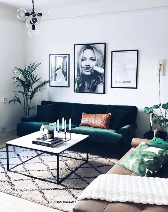 an emerald green velvet sofa echoes with greenery and leaf print pillows and makes this space lively