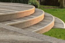 antique oak millboard decking looks beautiful with green grass and bushes and add a chic feel to the space