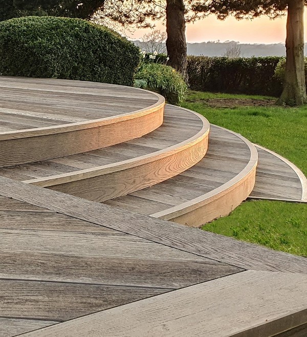 antique oak millboard decking looks beautiful with green grass and bushes and add a chic feel to the space