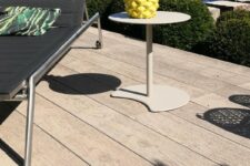 smoked oak decking, a black lounger, a neutral side table, a yellow pineapple and a tropical pillow for outdoors