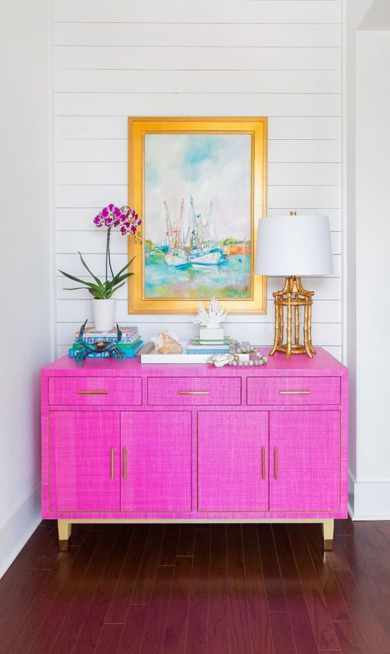 a jaw-dropping hot pink grasscloth paper sideboard with gold legs and bright decor will make a statement with color and texture