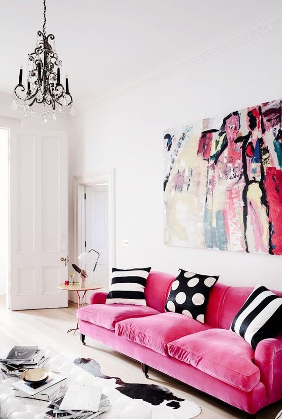 a pink velvet sofa makes a statement with texture and with bright color, black and white pillows create a contrast