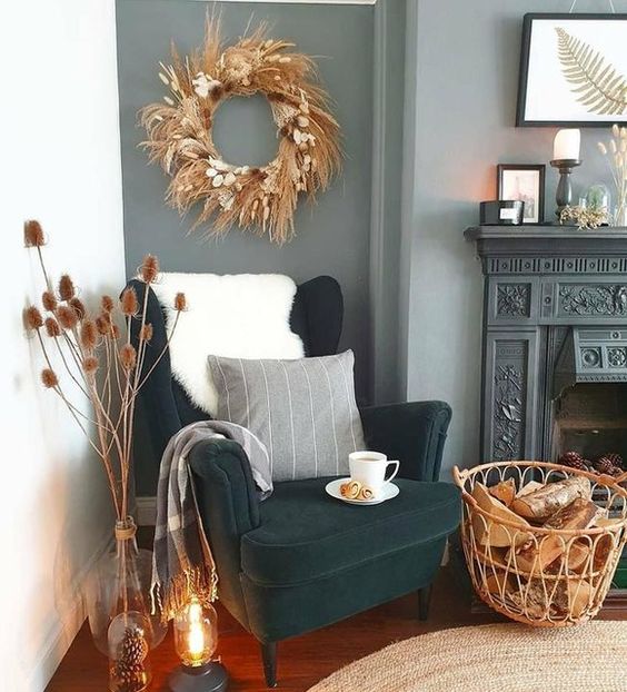 a beautiful nook with a non-working fireplace, a dark green Strandmon chair, a basket, a boho wreath and some candles