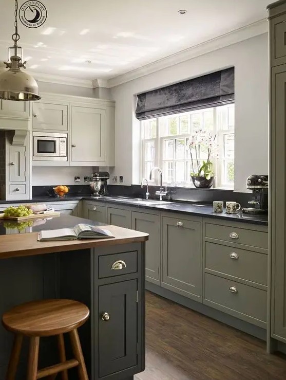 مطابخ باللون الاخضر الزيتي A-chic-modern-country-kitchen-in-olive-green-with-black-and-butcherblock-countertops-a-vintage-pendant-lamp-and-shiny-knobs