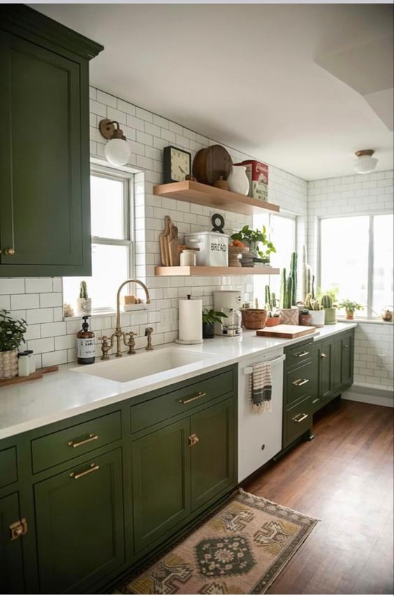 مطابخ باللون الاخضر الزيتي A-chic-modern-meets-boho-kitchen-with-olive-green-shaker-cabients-white-stone-countertops-white-subway-tiles-and-open-shelves