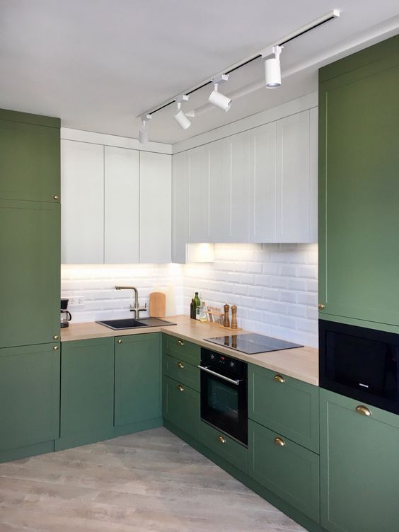 a minimalist olive green and white kitchen with shaker and flat panel cabinets, a white subway tile backsplash and butcherblock countertops