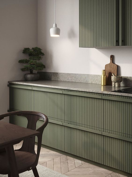 an elegant olive green kitchen with fluted cabinets, grey stone countertops, a white pendant lamp is a cool idea