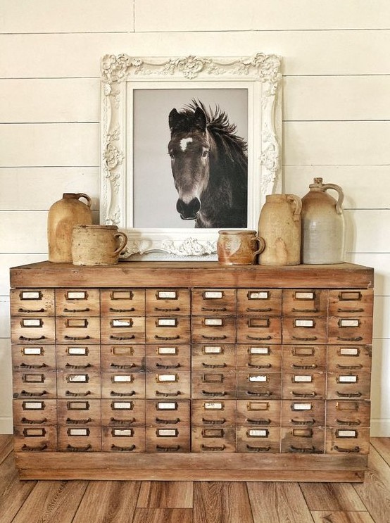 a beautiful vintage light-stained card cbainet with vintage vases and an artwork is a lovely solution for a rustic or vintage space