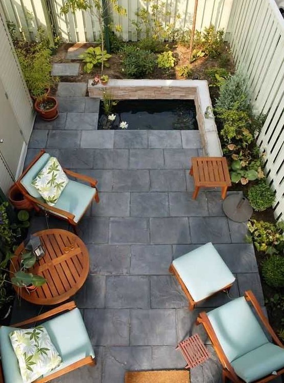 a small and zen like backyard with tiles on the ground, a tiny pond, some growing plants and cool garden furniture with blue upholstery a small and zen-like backyard with tiles on the ground, a tiny pond, some growing plants and cool garden furniture with blue upholstery
