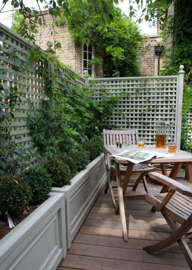 a small and cozy backyard with a deck, a simple wooden outdoor furniture set, potted greenery and climbing plants is very cozy a small and cozy backyard with a deck, a simple wooden outdoor furniture set, potted greenery and climbing plants is very cozy
