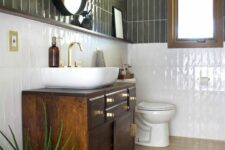 09 a mid-century modern bathroom with olive green and white skinny tiles, a dark-stained vanity, an oval mirror and a potted plant