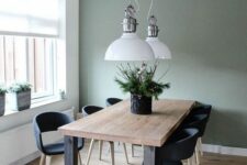 12 a modern farmhouse dining room with an olive green accent wall, a stained wood dining table, black chairs, white pendant lamp