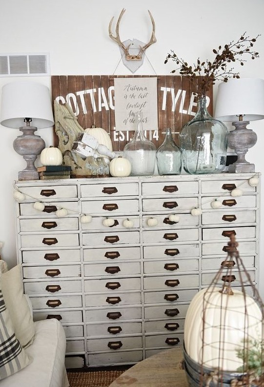 a neutral file cabinet as a living room console table with lots of storage is a cool idea for a cottage space