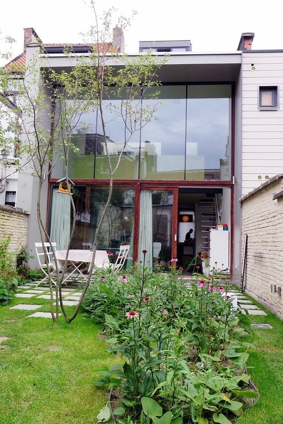 a small walled modern garden with a lawn, a tree, some blooms and greenery and a white dining set is very simple and cute a small walled modern garden with a lawn, a tree, some blooms and greenery and a white dining set is very simple and cute