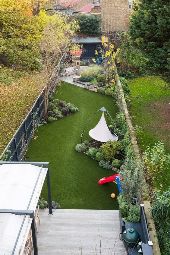 a long and narrow backyard featuring a grene lawn, some shrubs and trees, garden furniture and a stepped deck a long and narrow backyard featuring a grene lawn, some shrubs and trees, garden furniture and a stepped deck