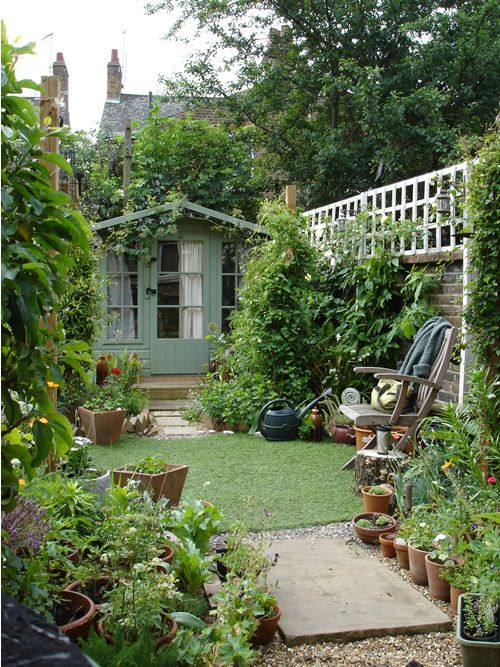 a small and narrow garden with a green lawn, greenery and shrubs, potted plants and a chair with a side table a small and narrow garden with a green lawn, greenery and shrubs, potted plants and a chair with a side table